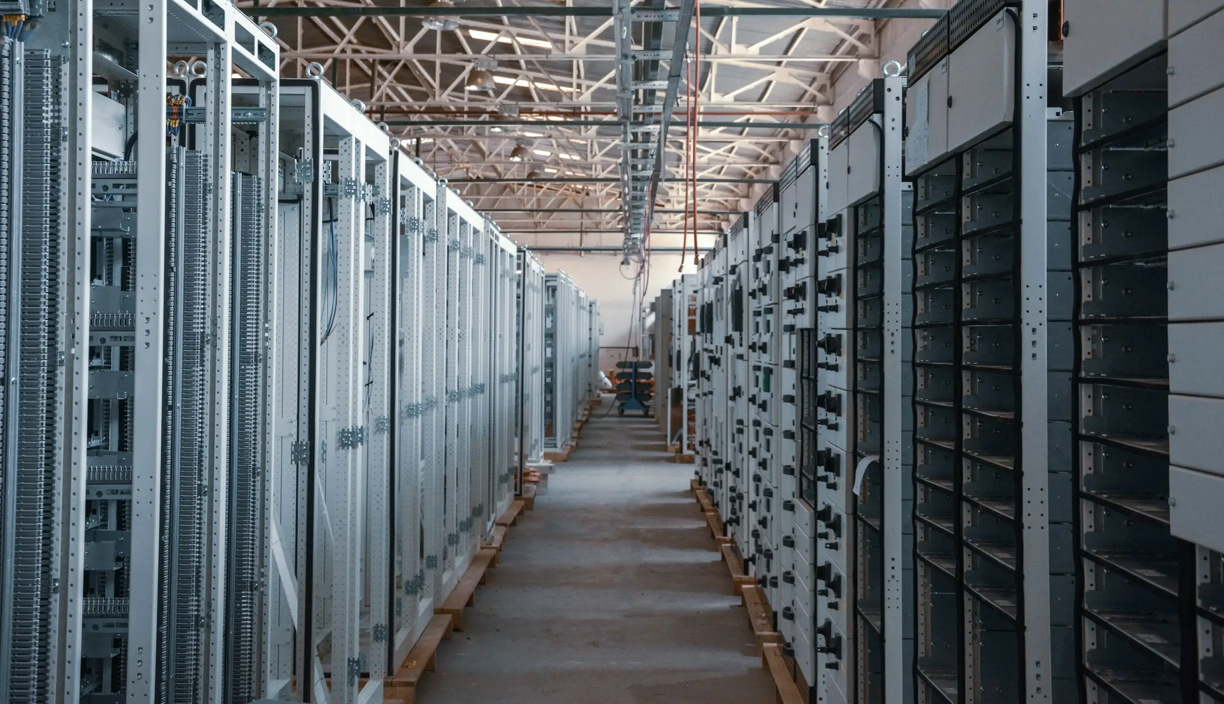 Rows of server racks inside a data center. Equipment of this density requires continuous cooling, which is the source of the noise neighbors report.